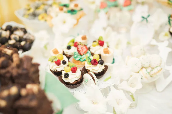 Deliciosa e saborosa mesa de sobremesa com cupcakes tiros na recepção closeup — Fotografia de Stock