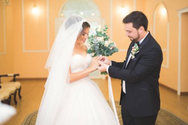 Güzellik gelin ve yakışıklı damat giyiyor birbirlerine yüzük. Düğün çift evlilik töreni üzerinde.