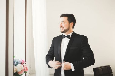 Güzel adam, damat poz veriyor ve düğüne hazırlanıyor.