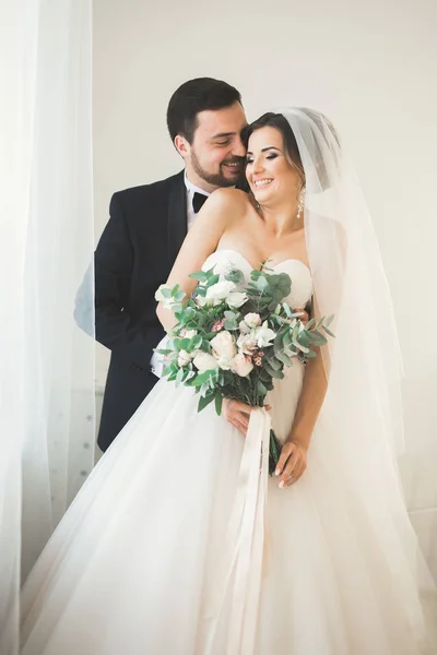 Sessão de fotos de casamento do casal recém-casados em um belo hotel posando perto da janela — Fotografia de Stock