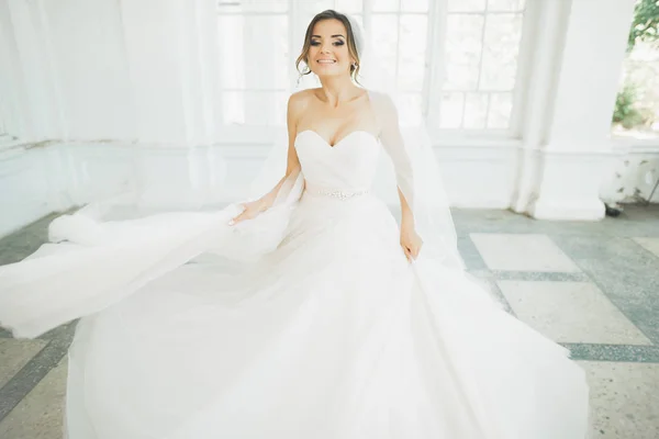 Bella sposa in abito da sposa con gonna lunga completa, sfondo bianco, danza e sorriso — Foto Stock