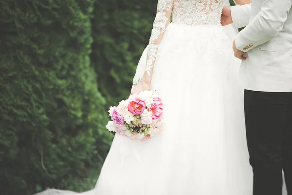 Casal de casamento perfeito segurando buquê de luxo de flores — Fotografia de Stock