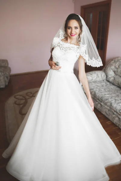 Linda noiva em roupão posando e se preparando para o rosto cerimônia de casamento em uma sala — Fotografia de Stock