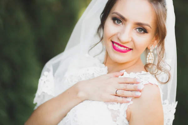 Linda noiva jovem de luxo em vestido de noiva posando no parque — Fotografia de Stock