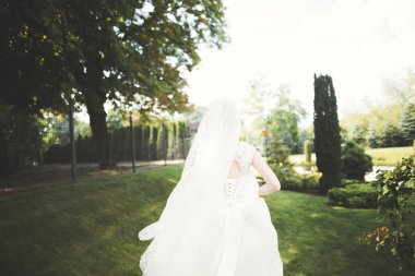 Gelinlik içinde dışarıda poz veren güzel gelin.