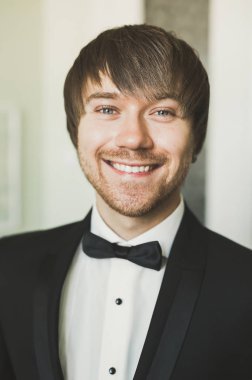 Güzel adam, damat poz veriyor ve düğüne hazırlanıyor.