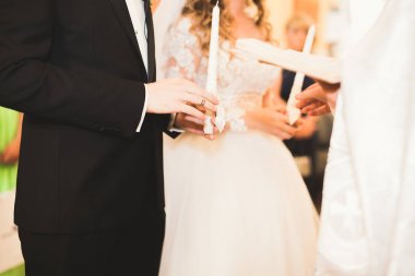 Gelin ve damat alyanslarını değiş tokuş ediyorlar. Şık bir çift töreni.