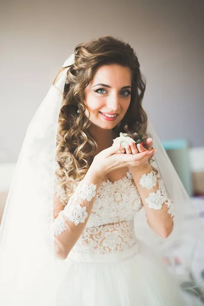 Noiva de luxo em vestido branco posando enquanto se prepara para a cerimônia de casamento — Fotografia de Stock
