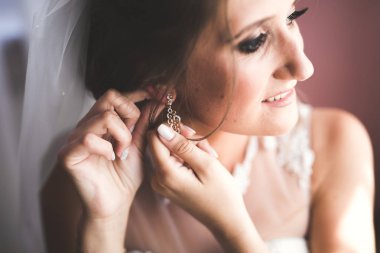 Beyaz elbiseli lüks gelin düğün törenine hazırlanırken poz veriyor.