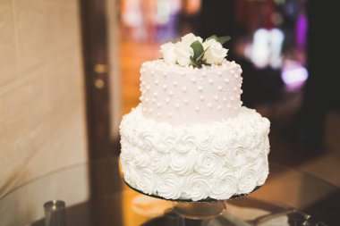 Masada süslü düğün pastası var.