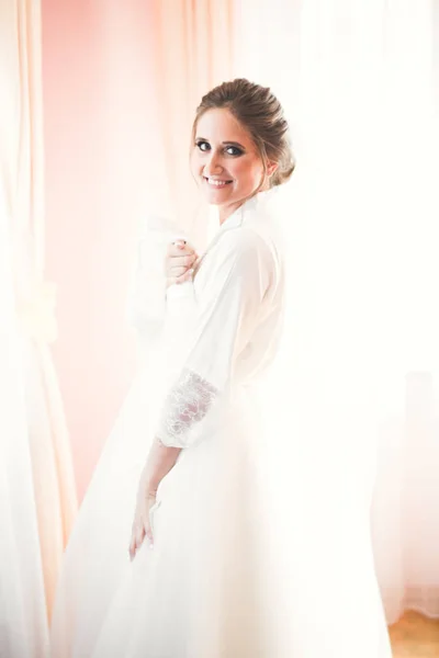 Noiva de luxo em vestido branco posando enquanto se prepara para a cerimônia de casamento — Fotografia de Stock