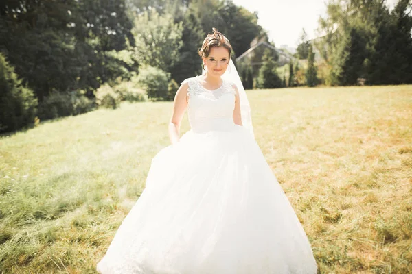 Krásná nevěsta spinning s perfektní šaty v parku — Stock fotografie
