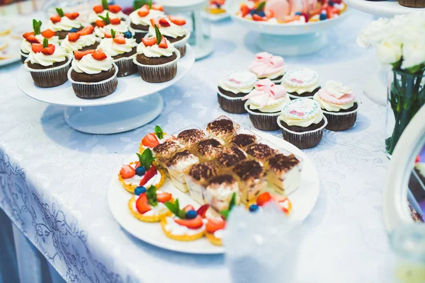 Deliciosa y sabrosa mesa de postres con cupcakes en primer plano de recepción — Foto de Stock