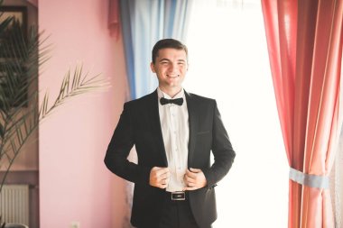 Güzel adam, damat poz veriyor ve düğüne hazırlanıyor.