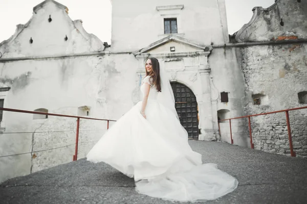 完璧なウェディング ドレスとブーケの古いお城に近いポーズ美しいエレガントな花嫁 — ストック写真