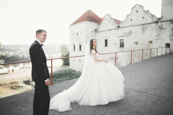 Güzel bir peri masalı yeni evli çift eski ortaçağ şatosunun yakınlarında sarılıyor. — Stok fotoğraf