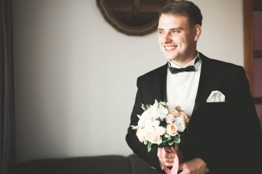 Güzel adam, damat poz veriyor ve düğüne hazırlanıyor.