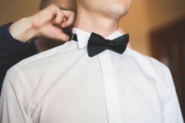 Yaka çiçeğiyle poz veren mutlu yakışıklı damat.