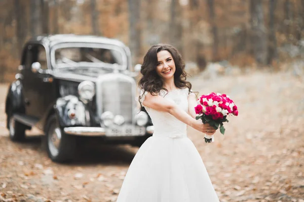 Nádherná elegantní nevěsta pózující v blízkosti stylové retro černé auto Luxusní svatba ve stylu vintage. Portrét — Stock fotografie