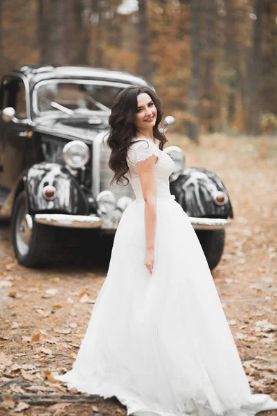Gelukkige bruid in de retro auto poseren op haar wieden dag — Stockfoto