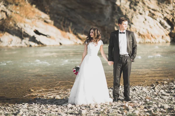 Svatební pár, ženich a nevěsta objímání, venku u řeky — Stock fotografie
