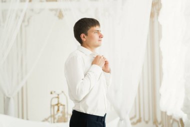 Güzel adam, damat poz veriyor ve düğüne hazırlanıyor.