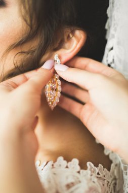 Cüppeli muhteşem gelin bir odada düğün töreni için poz veriyor ve hazırlanıyor.