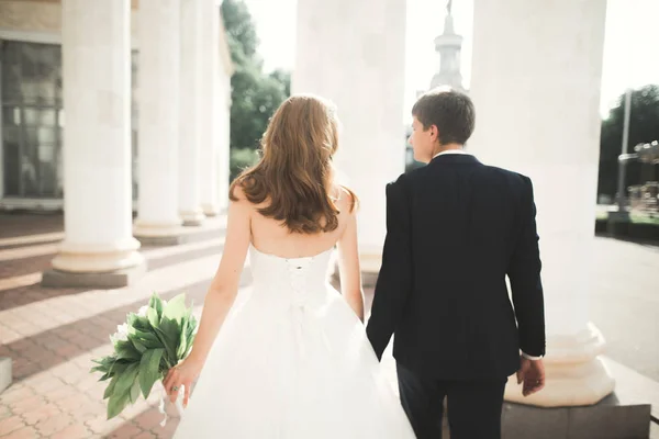 Ravissant couple de mariage heureux, mariée avec longue robe blanche posant dans la belle ville — Photo