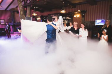 Güzel beyaz bir çift yeni evlendiler ve ilk danslarını ediyorlar.