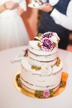 Gelin ve damat düğün pastasını kesiyor.