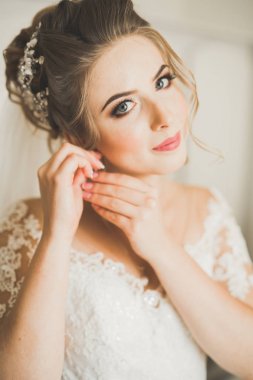 Beyaz elbiseli lüks gelin düğün törenine hazırlanırken poz veriyor.