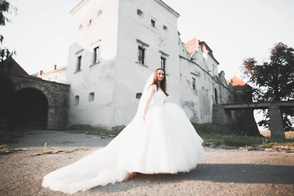 美丽优雅新娘完美婚纱和摆在老城堡附近的花束 — 图库照片