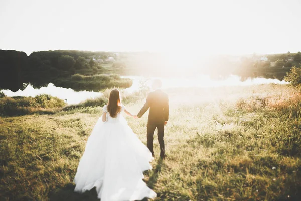 Beau couple de mariage romantique de jeunes mariés câlins dans le parc au coucher du soleil — Photo