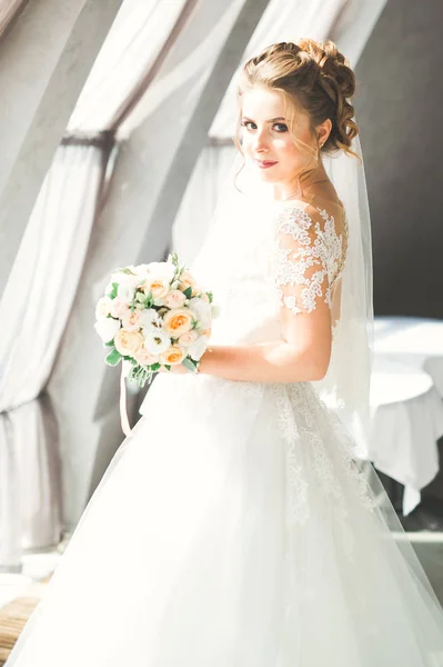 Portret van een prachtige bruid met lang haar poseren met grote boeket — Stockfoto