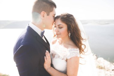 Güzel bir sahilde poz veren genç bir çiftin mutlu ve romantik sahnesi.