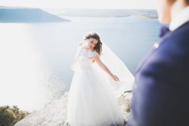 Güzel bir sahilde poz veren genç bir çiftin mutlu ve romantik sahnesi.