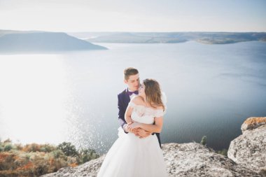 Güzel bir sahilde poz veren genç bir çiftin mutlu ve romantik sahnesi.