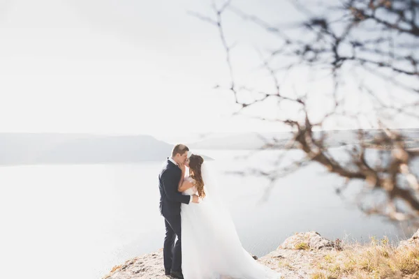 Κομψό κομψό ευτυχισμένο ζευγάρι γάμου, νύφη, πανέμορφο γαμπρό στο φόντο της θάλασσας και του ουρανού — Φωτογραφία Αρχείου