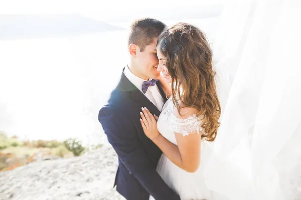 Glückliche und romantische Szene von frisch verheirateten jungen Hochzeitspaaren, die am schönen Strand posieren — Stockfoto