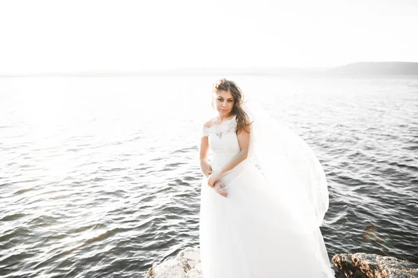 Hermosa novia romántica en vestido blanco posando en el mar de fondo —  Fotos de Stock