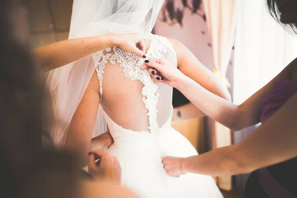 Hermosa novia con vestido de novia de moda con plumas con maquillaje de lujo deleite y peinado, estudio sesión de fotos interior — Foto de Stock