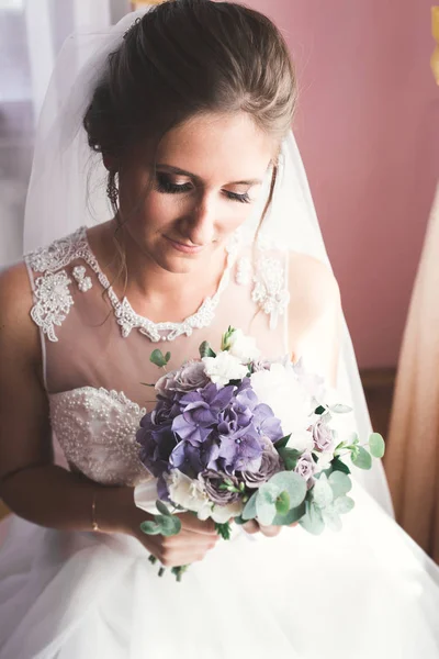 Novia de lujo en vestido blanco posando mientras se prepara para la ceremonia de boda — Foto de Stock