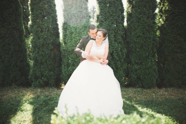 Yeni evli çift el ele tutuşurken parkta koşup zıplıyorlar.