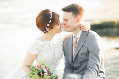 Gelin ve damat güzel düğün buket tutarak. Nehir kenarında poz