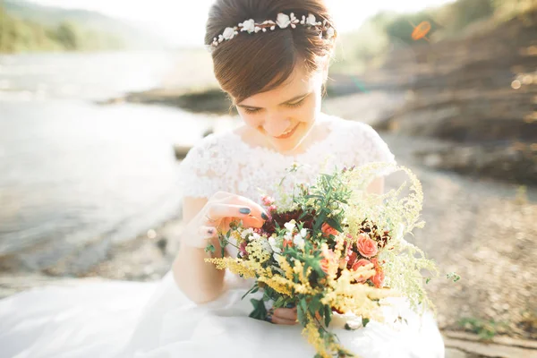 Senhora bonita, noiva em um vestido de noiva posando perto do rio — Fotografia de Stock