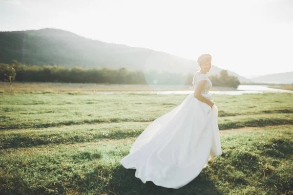 Красивая свадебная невеста бегает в саду — стоковое фото
