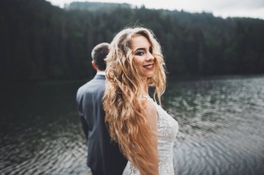 Harika bir gelin damada poz veriyor ve harika manzaralı dağlarda lüks bir tören yapıyor.