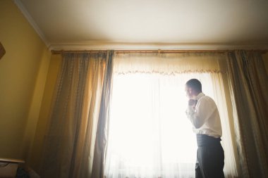 Güzel adam, damat poz veriyor ve düğüne hazırlanıyor.