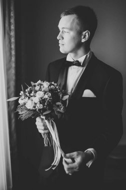 Güzel adam, damat poz veriyor ve düğüne hazırlanıyor.