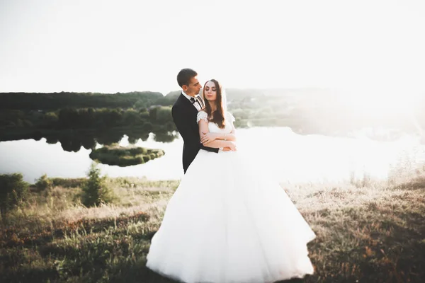 Newly married couple running and jumping in park while holding hands — Stock Photo, Image